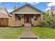 Charming brick home featuring a red front door, manicured lawn, and lovely curb appeal at 3649 N Garfield St, Denver, CO 80205
