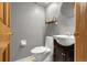 Neutral-toned powder bathroom featuring a modern vanity, toilet, and decorative shelf at 12414 Clayton Way, Thornton, CO 80241