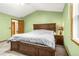 Green bedroom with large bed, carpeted floors, and classic wooden furniture at 12414 Clayton Way, Thornton, CO 80241