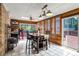Bright sunroom dining area with tiled floors, wood paneling, and access to outdoor deck at 12414 Clayton Way, Thornton, CO 80241