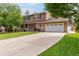 Charming two-story home featuring a well-manicured lawn, mature trees, and a long driveway at 12414 Clayton Way, Thornton, CO 80241