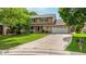 Charming two-story home featuring a well-manicured lawn, mature trees, and a long driveway at 12414 Clayton Way, Thornton, CO 80241