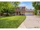 Charming two-story home featuring a well-manicured lawn, mature trees, and a long driveway at 12414 Clayton Way, Thornton, CO 80241