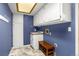 Well-lit laundry room with storage cabinets, a sink, and stylish blue walls at 12414 Clayton Way, Thornton, CO 80241