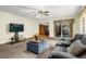 Comfortable living room featuring plush seating, a ceiling fan, and seamless access to the kitchen and dining areas at 12414 Clayton Way, Thornton, CO 80241