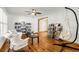 Bright living room with hardwood floors, bookshelves, a ceiling fan, and a hanging chair at 12414 Clayton Way, Thornton, CO 80241