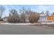 Exterior view of home featuring white siding, an attached garage, and established landscaping at 1195 Ammons St, Lakewood, CO 80214