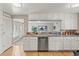 Bright kitchen featuring white cabinets, stainless steel dishwasher, and granite countertops at 1195 Ammons St, Lakewood, CO 80214