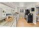 Updated kitchen featuring light wood flooring, stone countertops, and stainless steel appliances at 1195 Ammons St, Lakewood, CO 80214