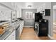 Bright kitchen with updated black appliances, white cabinets and a marble-style countertop at 1195 Ammons St, Lakewood, CO 80214