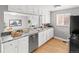 Well-lit kitchen with stainless steel appliances, white cabinetry and a marble-style countertop at 1195 Ammons St, Lakewood, CO 80214