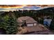 This beautiful home features a three-car garage, manicured landscaping, and a serene wooded backdrop at 730 Summerwood Dr, Golden, CO 80401