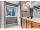 Bathroom with window, wood vanity, and neutral tile at 730 Summerwood Dr, Golden, CO 80401
