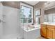 Well-lit bathroom with a soaking tub, glass-enclosed shower and modern fixtures at 730 Summerwood Dr, Golden, CO 80401