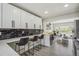 Well-appointed kitchen with white cabinets, black backsplash, and a stylish countertop bar adjacent to the living room at 3540 E 91St Ave, Thornton, CO 80229