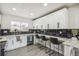 Well-appointed kitchen with white cabinets, black backsplash, and a stylish countertop bar with comfortable seating at 3540 E 91St Ave, Thornton, CO 80229
