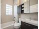 Bright bathroom featuring a tub with glass-block window and a sleek vanity with modern fixtures at 1532 Meade St, Denver, CO 80204