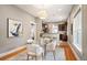 Dining area with a modern chandelier, a glass table with white chairs, and hardwood floors at 1532 Meade St, Denver, CO 80204
