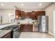 Contemporary kitchen with stainless steel appliances, granite countertops, and dark wood cabinetry at 1532 Meade St, Denver, CO 80204