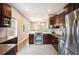 Well-lit kitchen with stainless steel appliances, stone countertops, and modern dark wood cabinets at 1532 Meade St, Denver, CO 80204