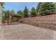 The backyard has a covered patio with a retaining wall adding character to the space at 4214 Kestrel Pl, Castle Rock, CO 80109