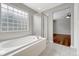 Bright bathroom featuring a soaking tub, glass block window, and glass door shower at 4214 Kestrel Pl, Castle Rock, CO 80109