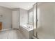 Bright bathroom featuring a soaking tub with tile surround and a glass door shower at 4214 Kestrel Pl, Castle Rock, CO 80109