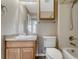 Neutral bathroom with tiled shower, toilet, and vanity with wooden cabinets at 4214 Kestrel Pl, Castle Rock, CO 80109