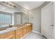 Bathroom featuring double sinks with light wood cabinetry and framed mirror at 4214 Kestrel Pl, Castle Rock, CO 80109