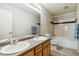Clean bathroom featuring a double vanity, large mirror, and bathtub shower combo at 12766 Jasmine St # D, Thornton, CO 80602