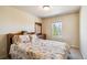 Comfortable bedroom with floral bedding, a window with natural light, and wood dresser at 12766 Jasmine St # D, Thornton, CO 80602