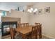 Charming dining area with a wooden table, elegant chandelier, and a view of the fireplace, ideal for Gathering meals at 12766 Jasmine St # D, Thornton, CO 80602
