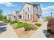 Well-maintained townhomes showcasing stone and siding exteriors, enhanced by mature landscaping and sidewalks, creating a desirable community at 12766 Jasmine St # D, Thornton, CO 80602