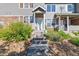 Welcoming front entrance with stone accents, featuring well-maintained landscaping and a concrete path leading to the door at 12766 Jasmine St # D, Thornton, CO 80602