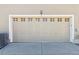 Attached garage door with decorative windows and exterior light fixture at a single Gathering home at 12766 Jasmine St # D, Thornton, CO 80602