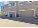 Exterior view of three garages attached to townhome complex with driveway access at 12766 Jasmine St # D, Thornton, CO 80602