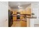 Charming kitchen with light wooden cabinets and stainless steel appliances, complete with tile flooring at 12766 Jasmine St # D, Thornton, CO 80602