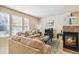 Bright living room with plush sofas, a fireplace, and large windows, creating a welcoming and comfortable space at 12766 Jasmine St # D, Thornton, CO 80602