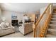 Cozy living room featuring plush sofas, a fireplace, and a staircase, creating a comfortable and inviting atmosphere at 12766 Jasmine St # D, Thornton, CO 80602