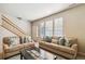 Spacious living room with comfortable sofas, a large window, and a staircase, creating a cozy and functional living space at 12766 Jasmine St # D, Thornton, CO 80602