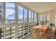 Bright sunroom has multiple windows and seating for eight at a wooden table at 9335 E Center Ave # 7B, Denver, CO 80247