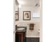 Charming powder room has a black sink and faucet, wainscoting, and a stylish framed print at 506 N Marion St, Denver, CO 80218