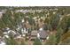 Aerial shot of a sprawling home with multiple structures, surrounded by lush trees and snowy patches at 6080 Kilimanjaro Dr, Evergreen, CO 80439