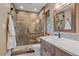 This bathroom features a glass enclosed shower with a built-in seat and a modern vanity with a quartz countertop at 6080 Kilimanjaro Dr, Evergreen, CO 80439