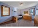 Comfortable bedroom features two windows, wood furnishings, and light blue walls at 6080 Kilimanjaro Dr, Evergreen, CO 80439