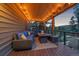 Covered deck with cozy seating and outdoor fireplace, perfect for enjoying the beautiful surroundings at 6080 Kilimanjaro Dr, Evergreen, CO 80439