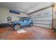 Spacious garage interior with stained floors, and a blue SUV, offering ample storage and parking at 6080 Kilimanjaro Dr, Evergreen, CO 80439