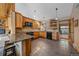 Bright kitchen features natural wood cabinets and beams, granite countertops, stainless steel appliances, and breakfast bar at 6080 Kilimanjaro Dr, Evergreen, CO 80439