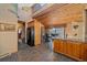 Eat-in kitchen features natural wood cabinets and beams, granite countertops, and modern black refrigerator at 6080 Kilimanjaro Dr, Evergreen, CO 80439