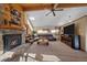 Comfortable living room featuring stone fireplace, wood beam ceiling, and large screen television at 6080 Kilimanjaro Dr, Evergreen, CO 80439